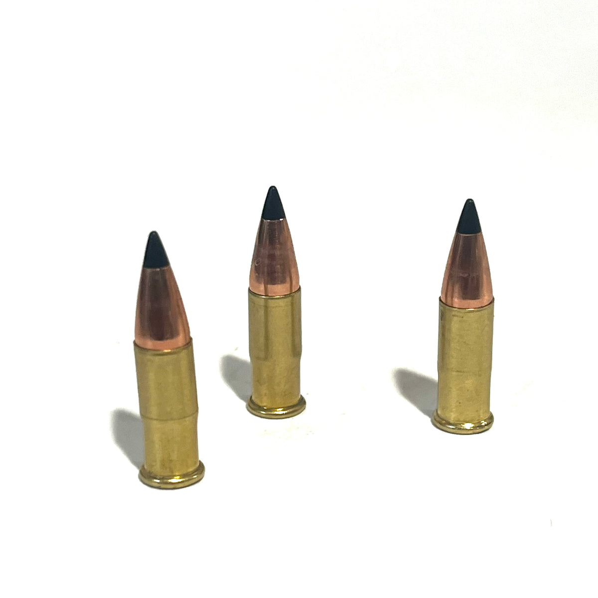 3 .22 caliber dummy rounds with black polymer bullet tips, standing upright on a white background
