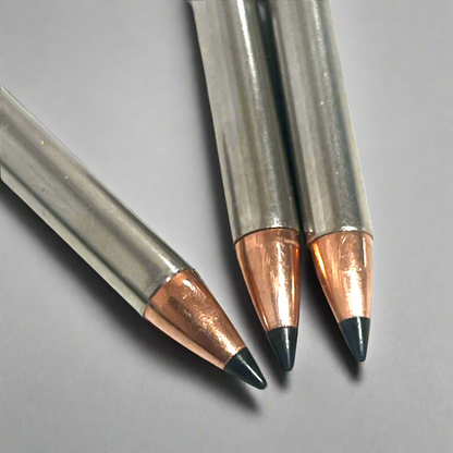 Close-up of 3 .22 Magnum nickel dummy round bullet tips showing copper jackets and black polymer points, gray background