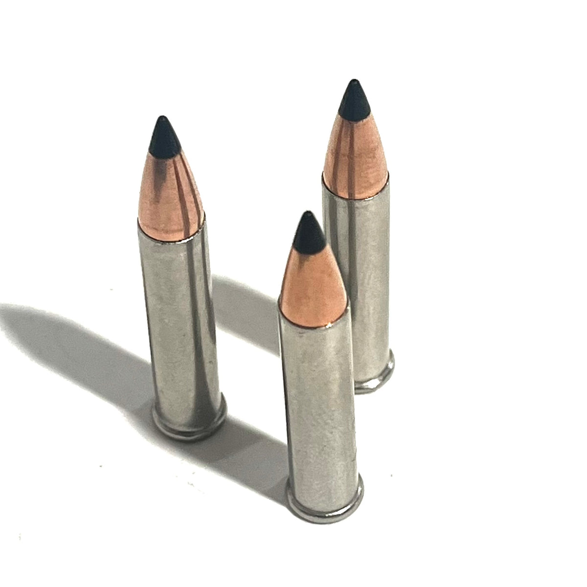 3 .22 Magnum nickel dummy rounds with black polymer tipped bullets standing upright on white background