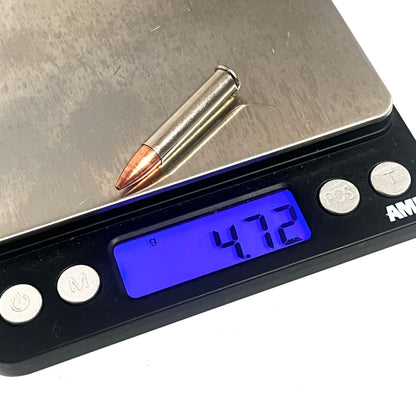 Single .22 Magnum nickel dummy round with copper bullet on a digital gram scale reading 4.72 grams