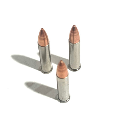 3 .22 Magnum nickel dummy rounds standing upright with copper bullets on white background