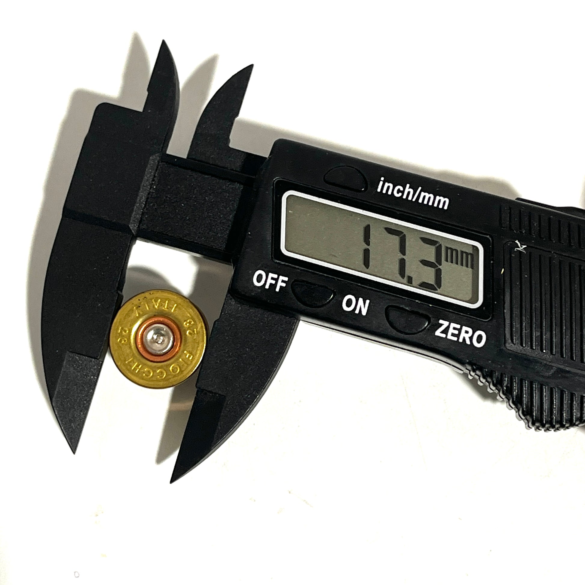 Digital caliper measuring a gold brass 28 gauge Fiocchi headstamp showing 17.3 mm on the screen.