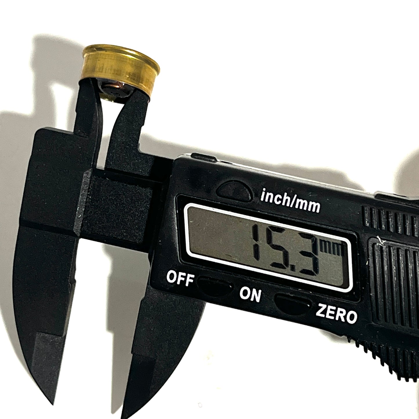 Digital caliper measuring a gold brass 28 gauge Fiocchi headstamp showing 15.3 mm on the display.