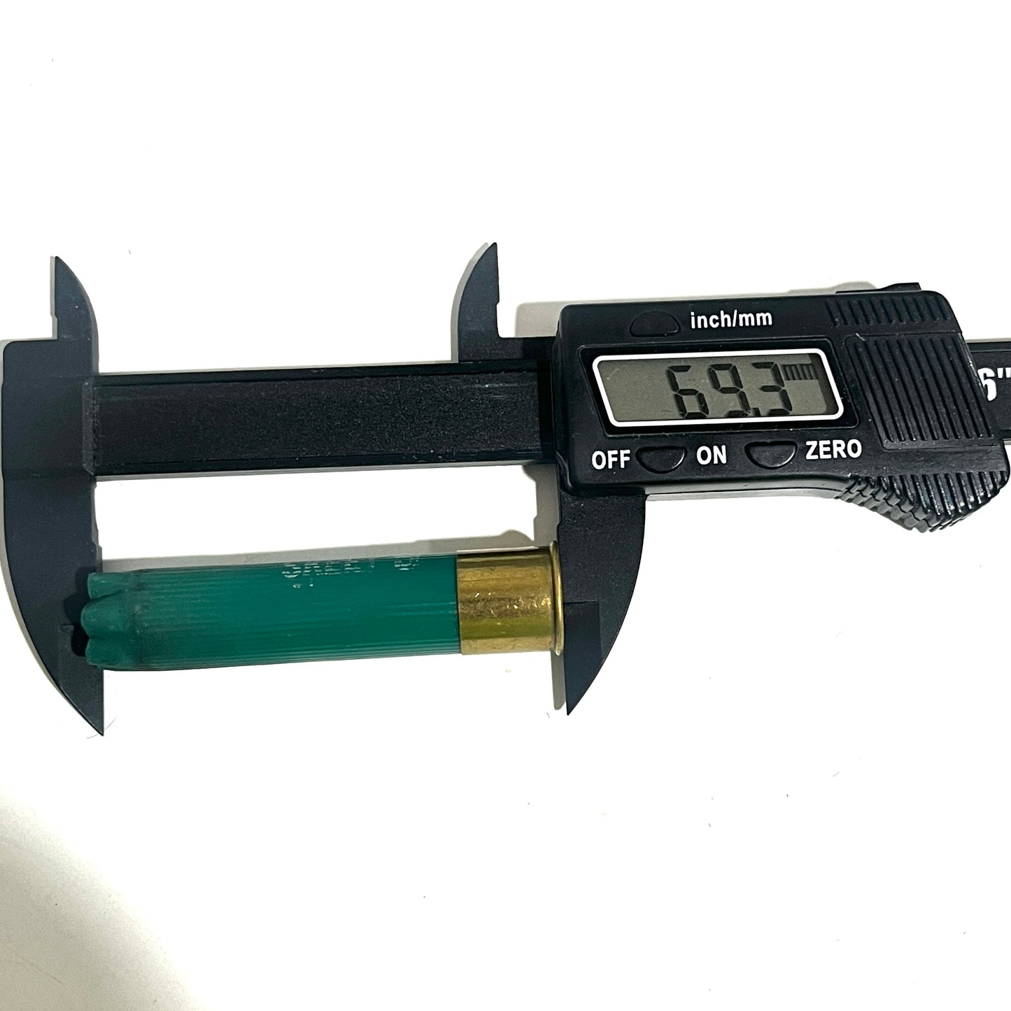 A black digital caliper measuring the overall length of a green 28 gauge empty shotgun hull, reading 69.3 mm.