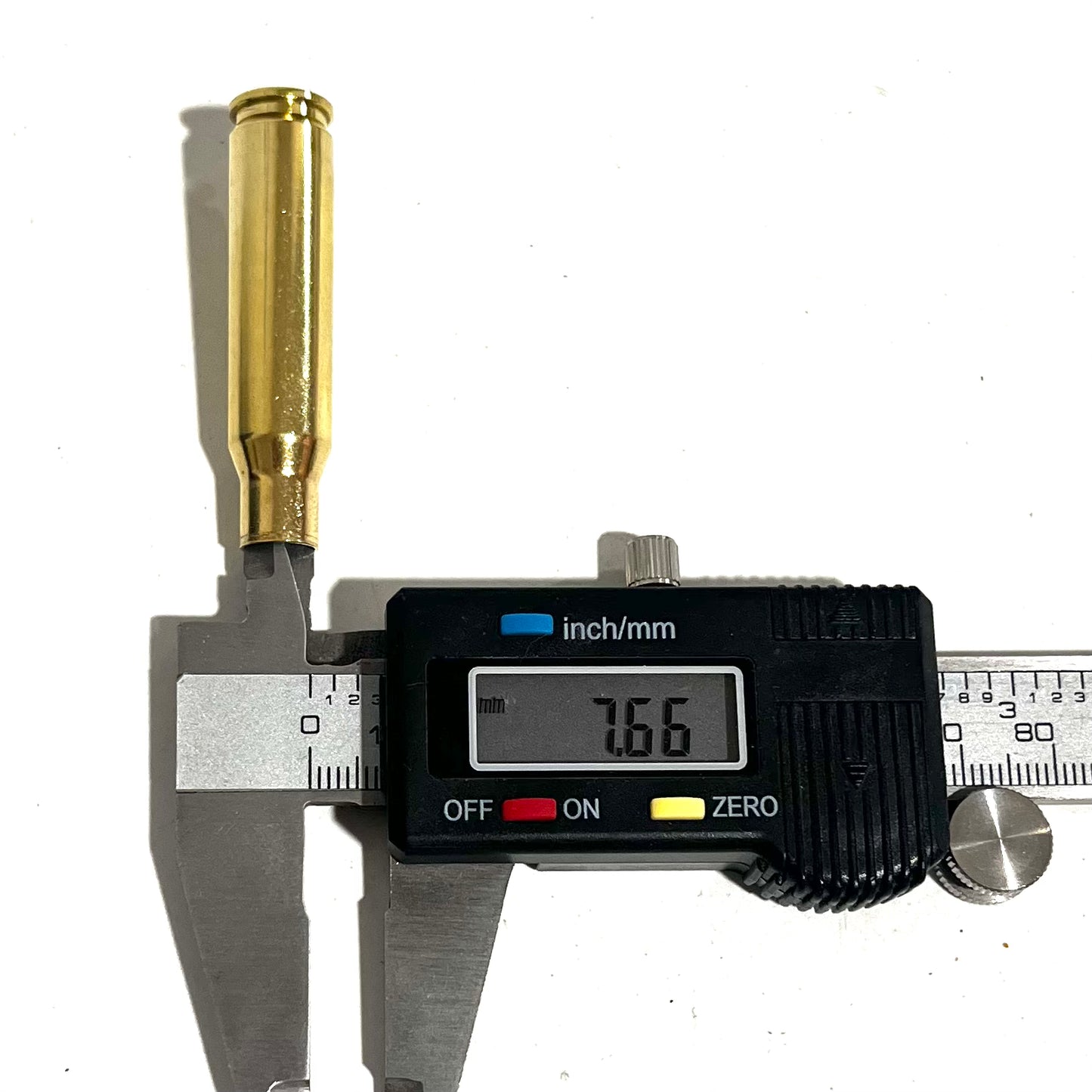 Digital caliper measuring the neck diameter of a gold 308 WIN brass shell, showing a readout of 7.66 mm.