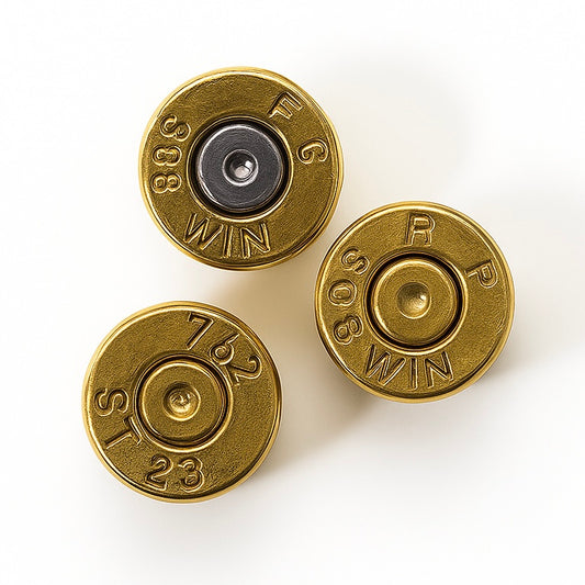 Three brass 308 WIN bullet slices showing headstamps, primers intact and inert, on white background