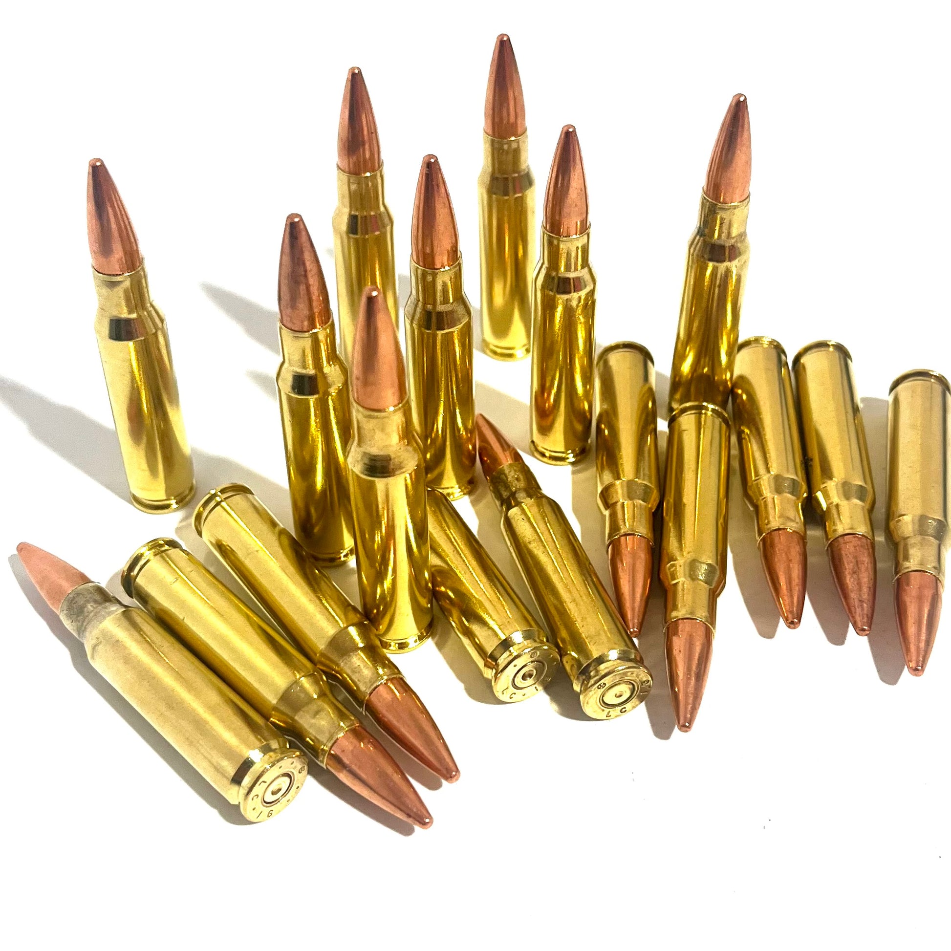 Large group of brass .308 dummy prop cartridges with copper tips, some standing and some lying flat