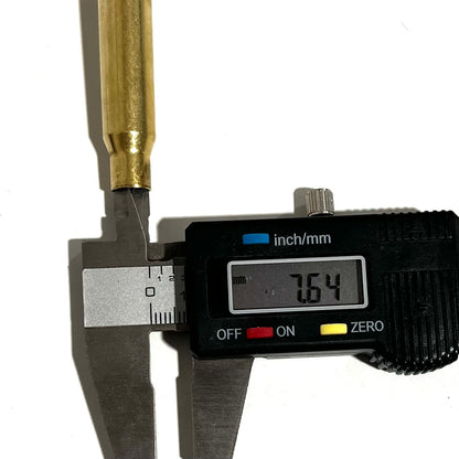 Digital caliper measuring the diameter of a 308 Winchester brass casing at 7.64 millimeters