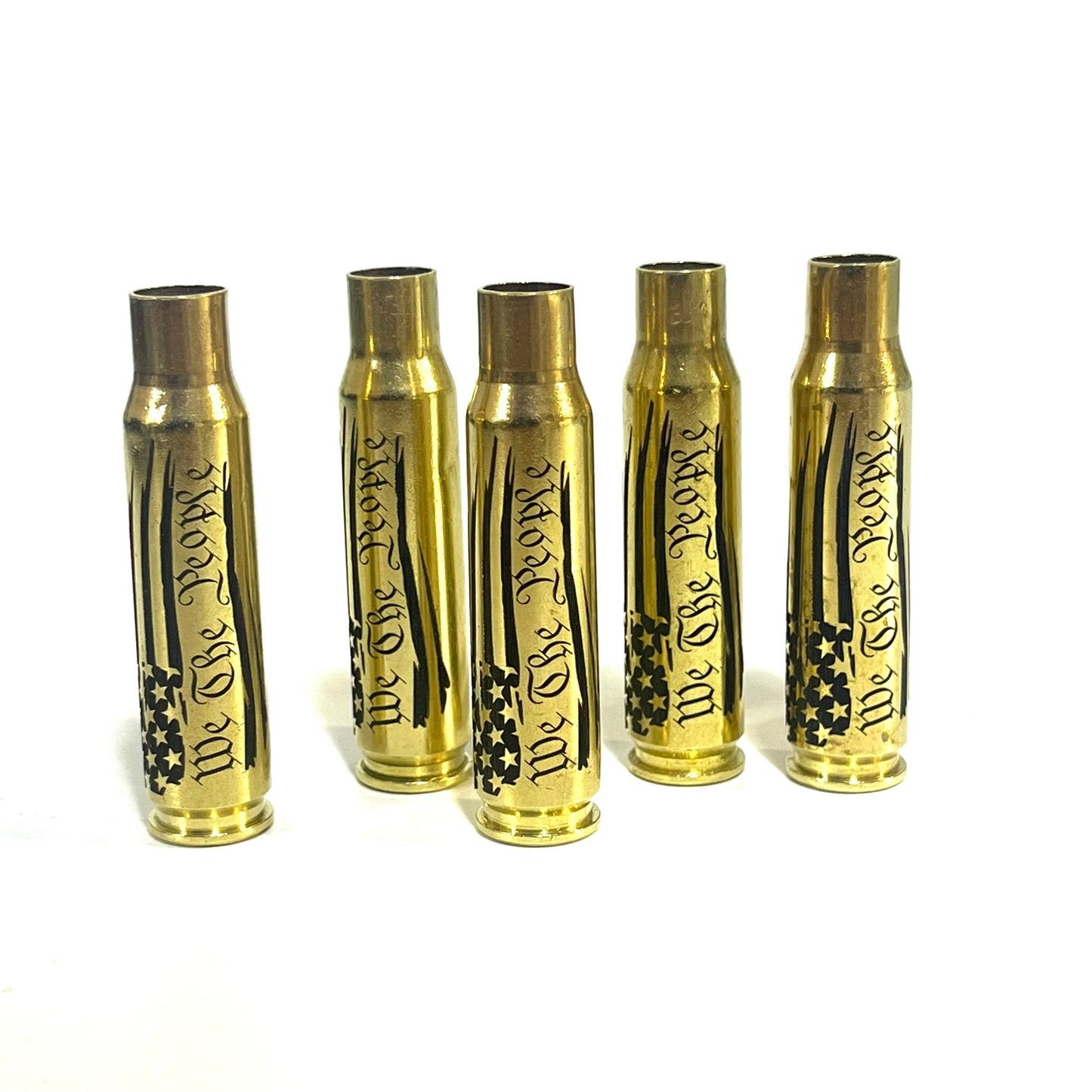 Five upright .308 WIN brass casings engraved with a We The People flag script design, arranged side-by-side.