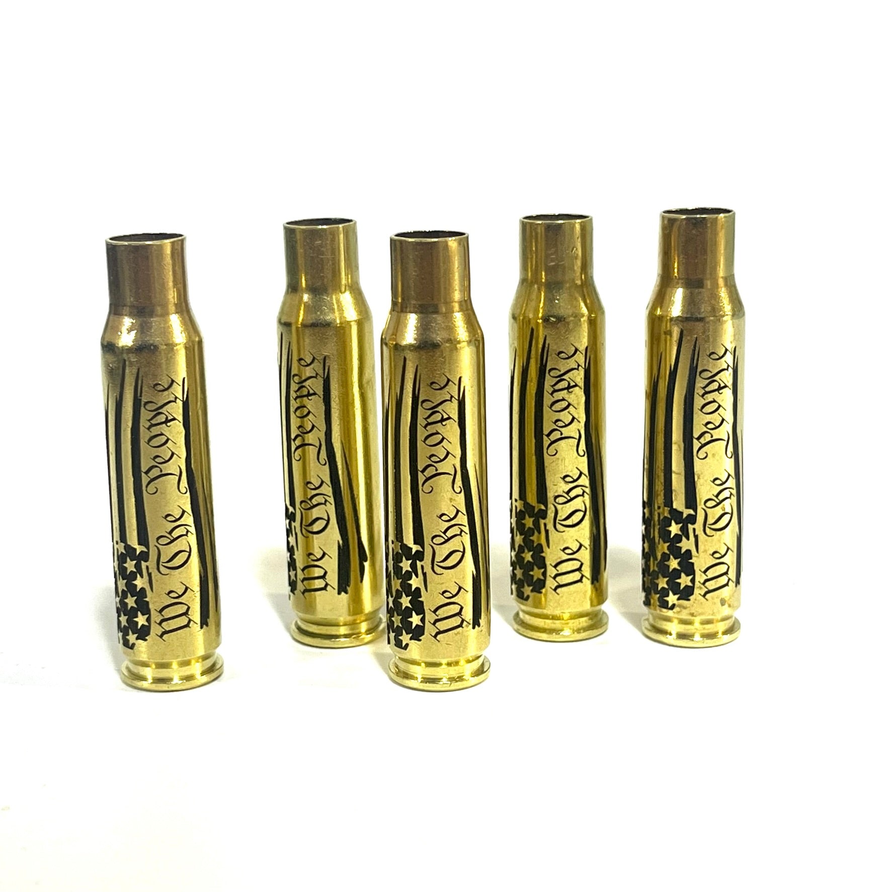 Five upright .308 WIN brass casings engraved with a We The People flag script design, arranged side-by-side.