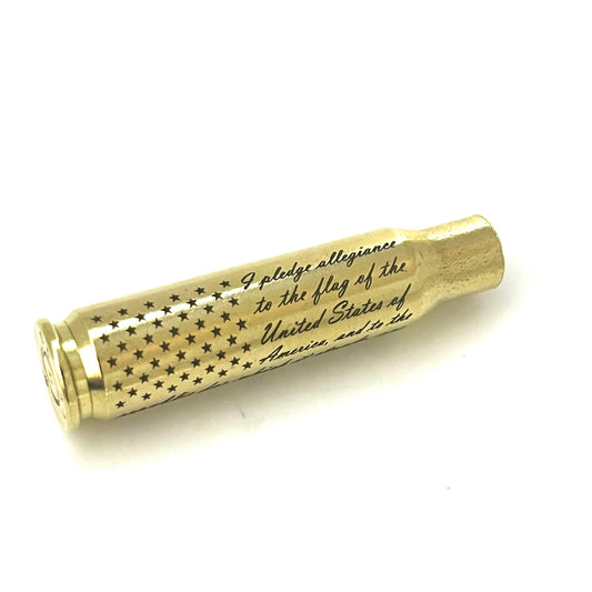 Engraved brass 308 WIN once-fired rifle shell with stars and Pledge of Allegiance script text on a white background