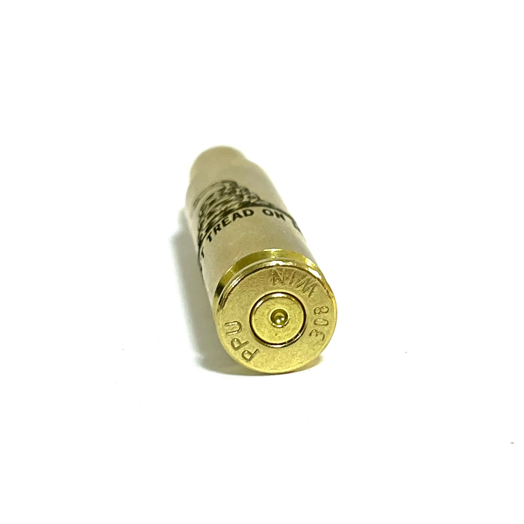 Close up view of a 308 WIN brass cartridge standing upright showing PPU base headstamp and engraved words.