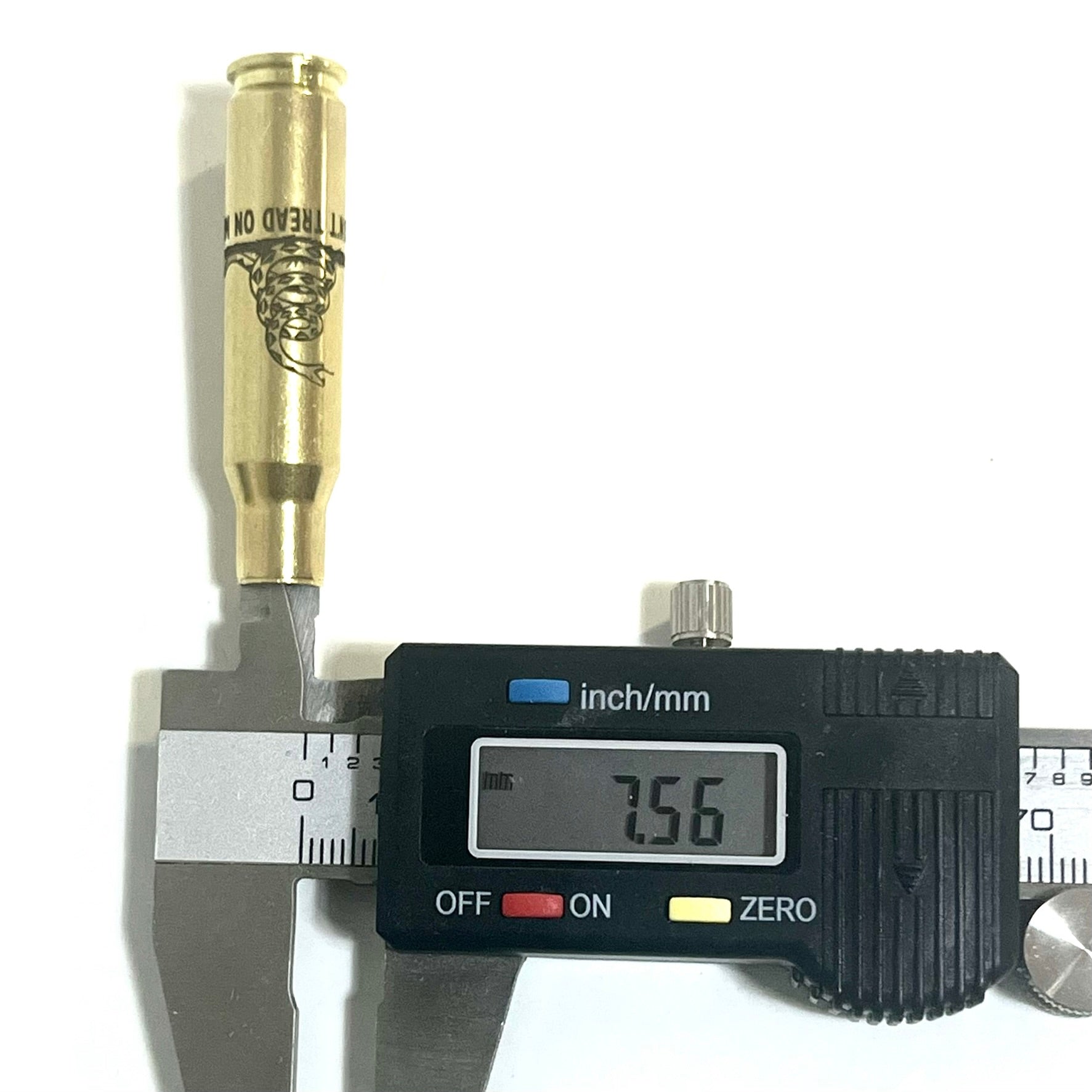 Single 308 WIN brass casing measured at neck with digital caliper showing 7.56 millimeter reading.