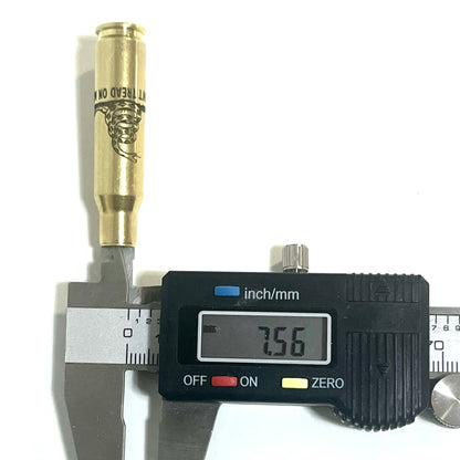 Single 308 WIN brass casing measured at neck with digital caliper showing 7.56 millimeter reading.