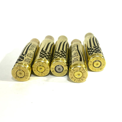 Five .308 WIN spent shells arranged with their circular gold and silver bases facing forward, showing stamped headstamps.