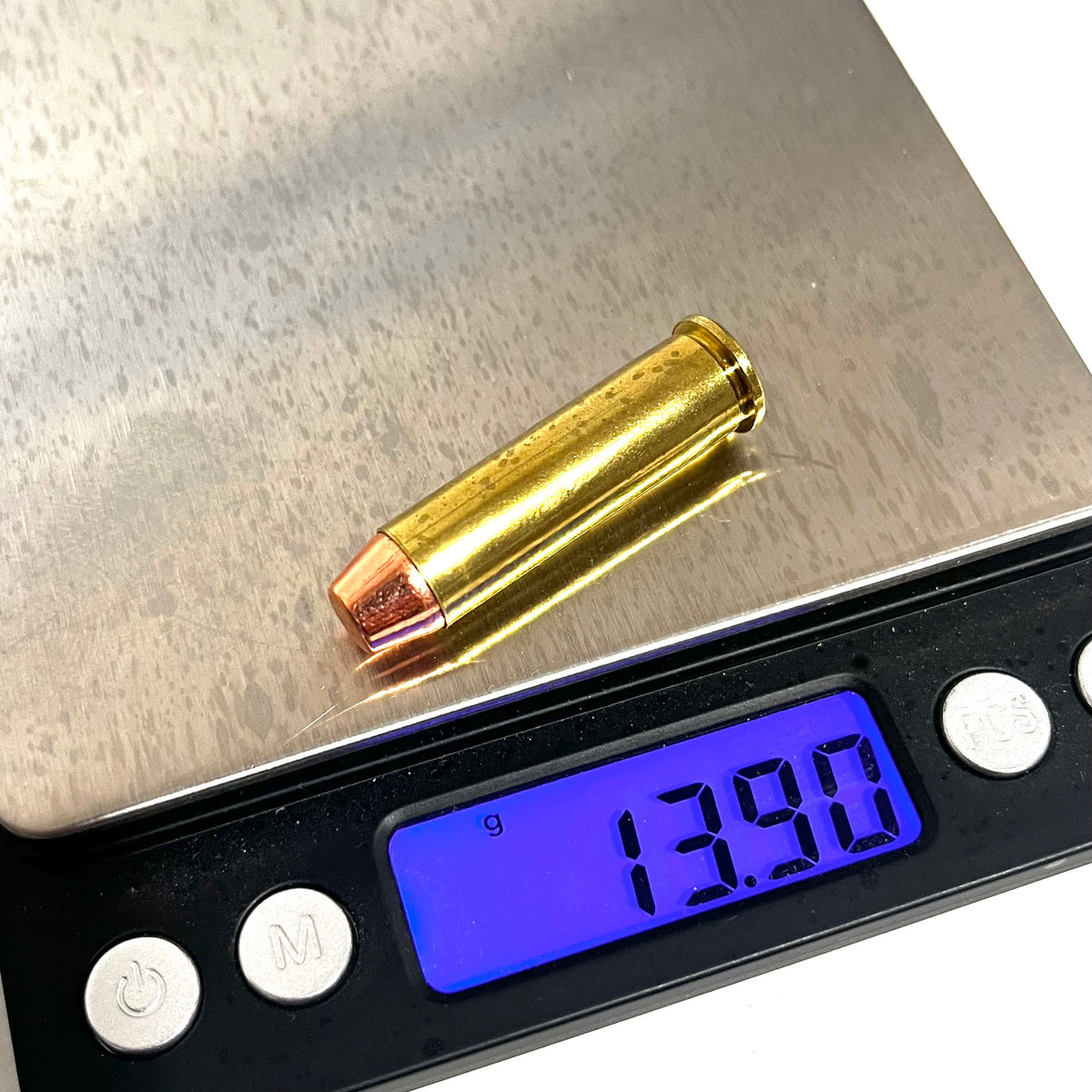 357 Magnum brass dummy round on a digital scale reading 13.90 grams