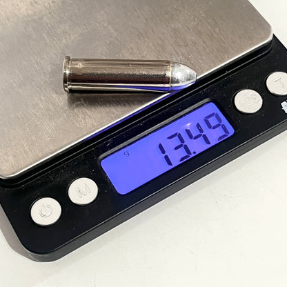Nickel 357 Magnum dummy round resting on a digital gram scale reading 13.49