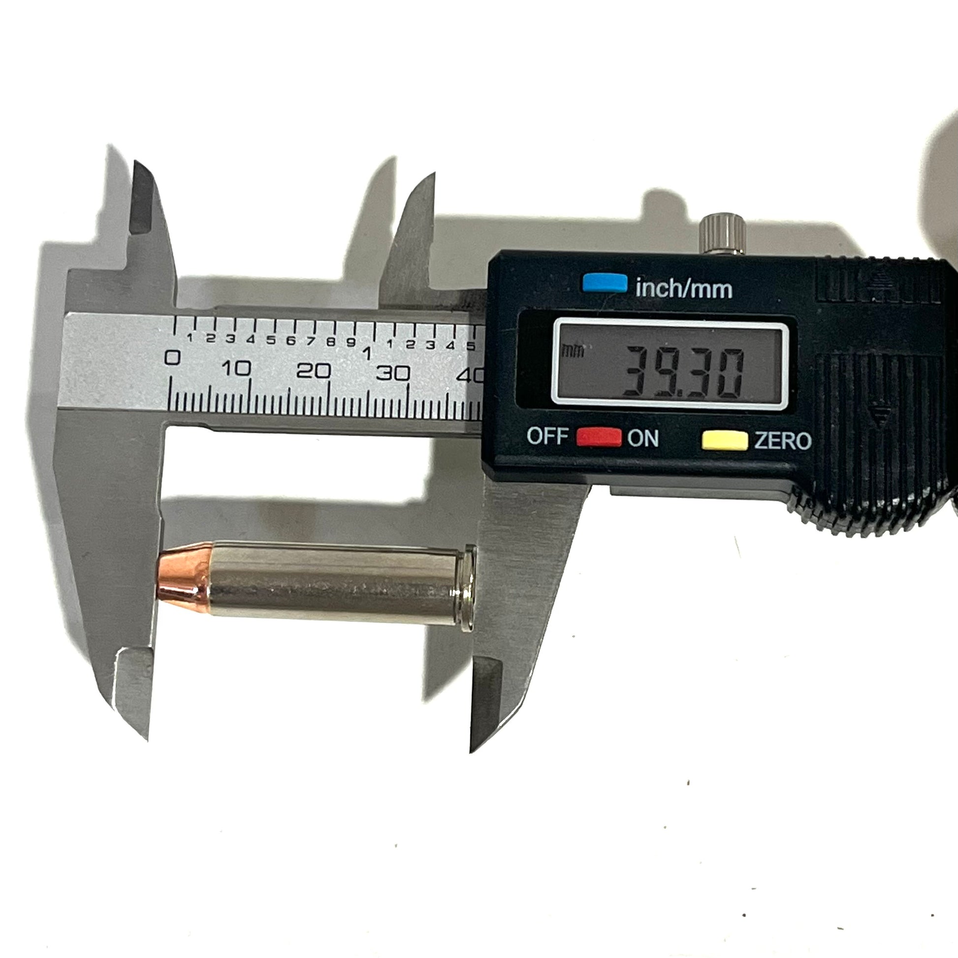 A digital caliper measuring the total length of a nickel 357 Magnum fake bullet with flat nose, showing 39.30 millimeters.