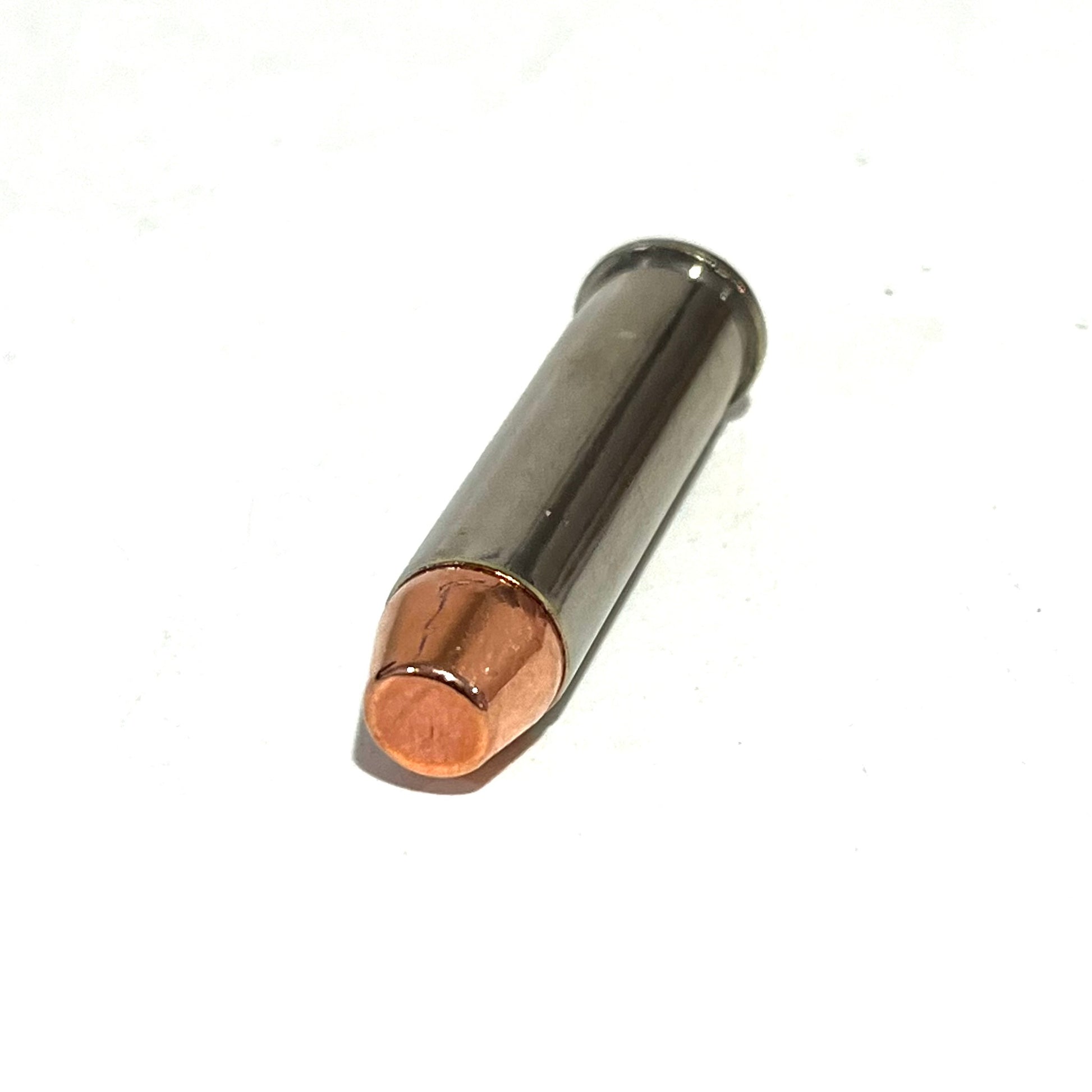 Single nickel fake bullet with a copper flat nose projectile lying diagonally on a white background with a soft shadow.