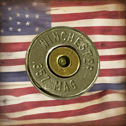 357 Magnum nickel bullet slice with WINCHESTER 357 MAG headstamp displayed against an American flag background