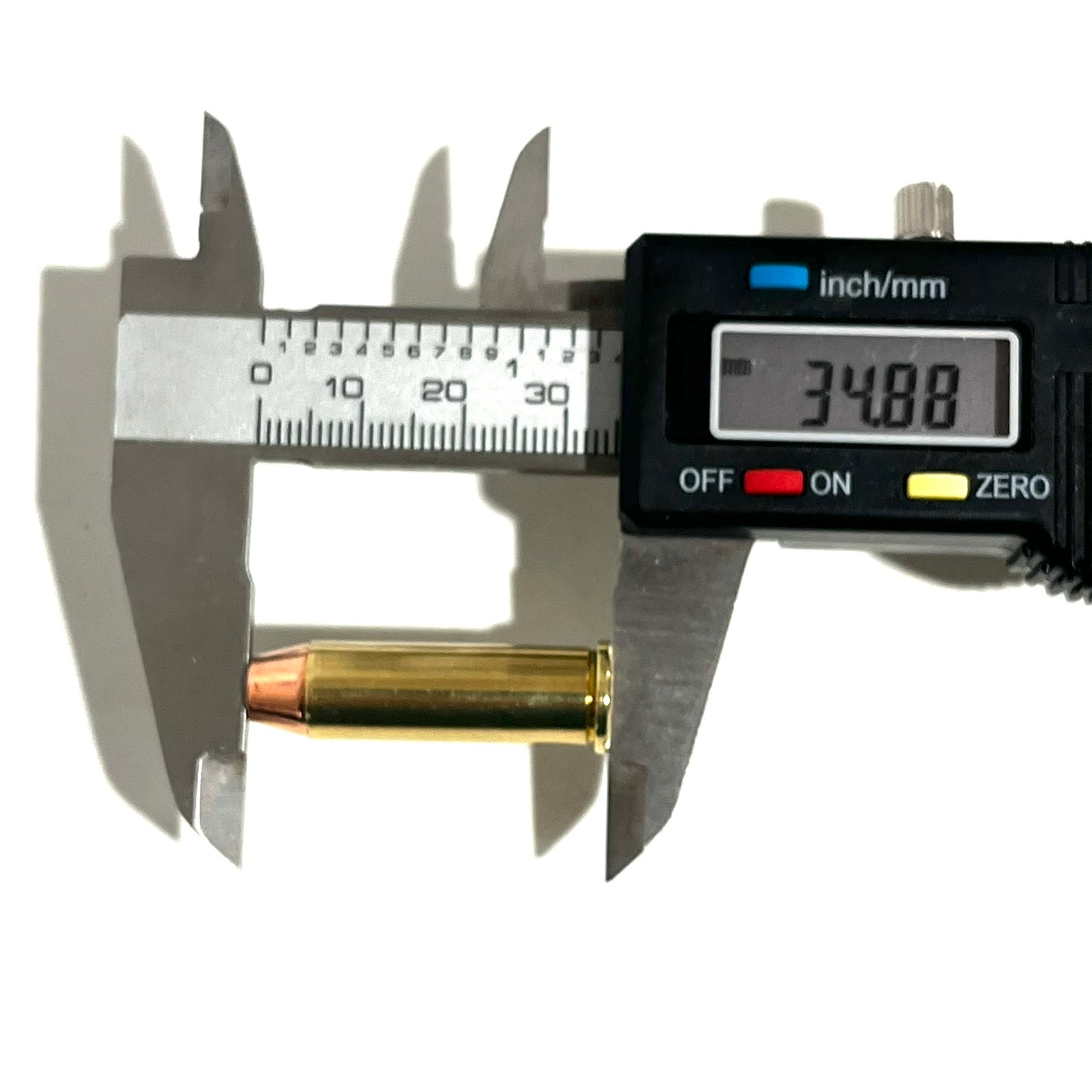 A digital caliper measuring the overall length of a single .38 Special brass dummy round, displaying an exact measurement of 34.88 mm.