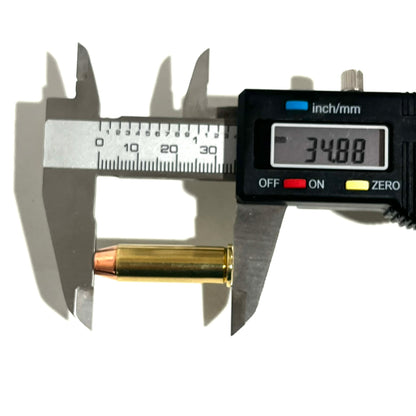 A digital caliper measuring the overall length of a single .38 Special brass dummy round, displaying an exact measurement of 34.88 mm.