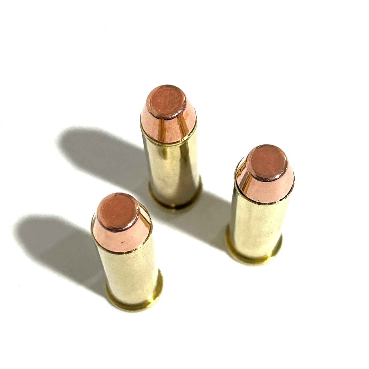 Three .38 Special brass inert cartridges standing closely together on a clean white background for props cosplay.
