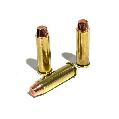 Two .38 Special brass dummy rounds on a white background; one standing upright and one laying flat on its side for movie props.