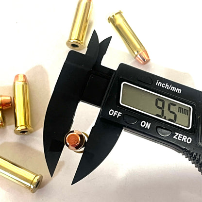 Digital caliper measuring a 38 Special flat nose bullet's diameter at 9.5 millimeters, with brass cases scattered nearby
