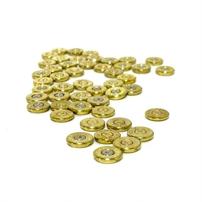 Pile of gold brass 40 S&W bullet slices with visible headstamps and primers on a white background