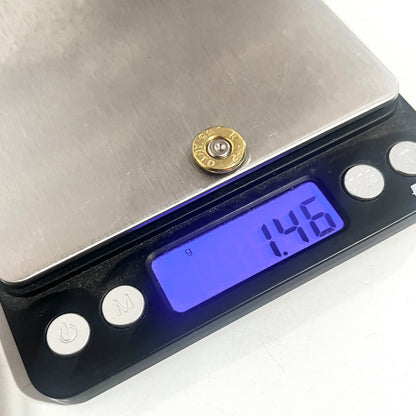 A single gold slice resting on a digital scale platform, display reading 1.46 grams.