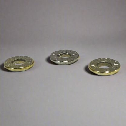 Three deprimed Winchester 45 Auto nickel cartridge slices arranged on a light grey reflective background.