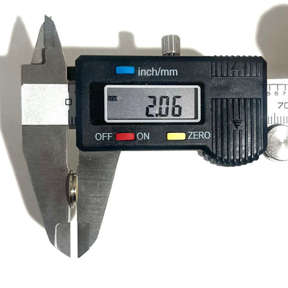 A digital caliper measuring a deprimed bullet casing slice, showing a thin-cut thickness reading of 2.06 mm.