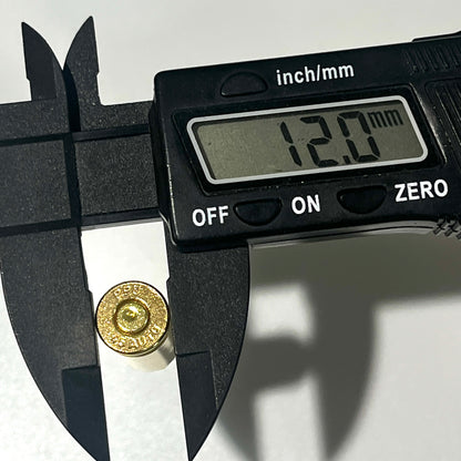A single gold 45 ACP brass shell measured by a digital caliper, display reading 12.0 mm, headstamp marked PPU 45 AUTO.