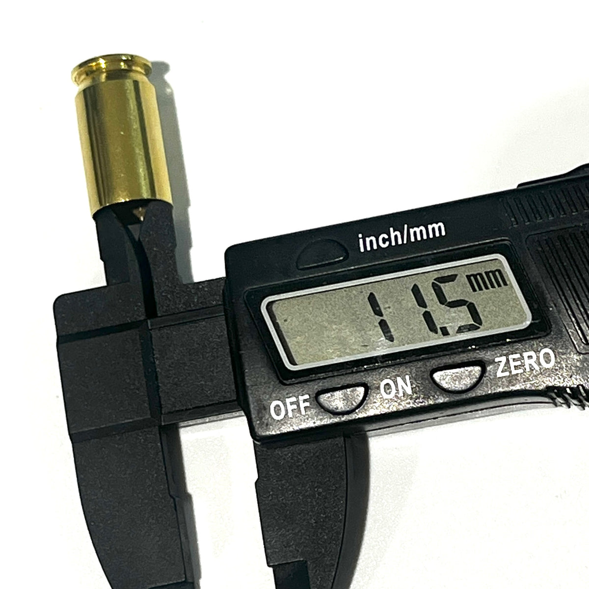 A gold 45 ACP brass casing's open mouth measured by a digital caliper, display reading 11.5 mm.