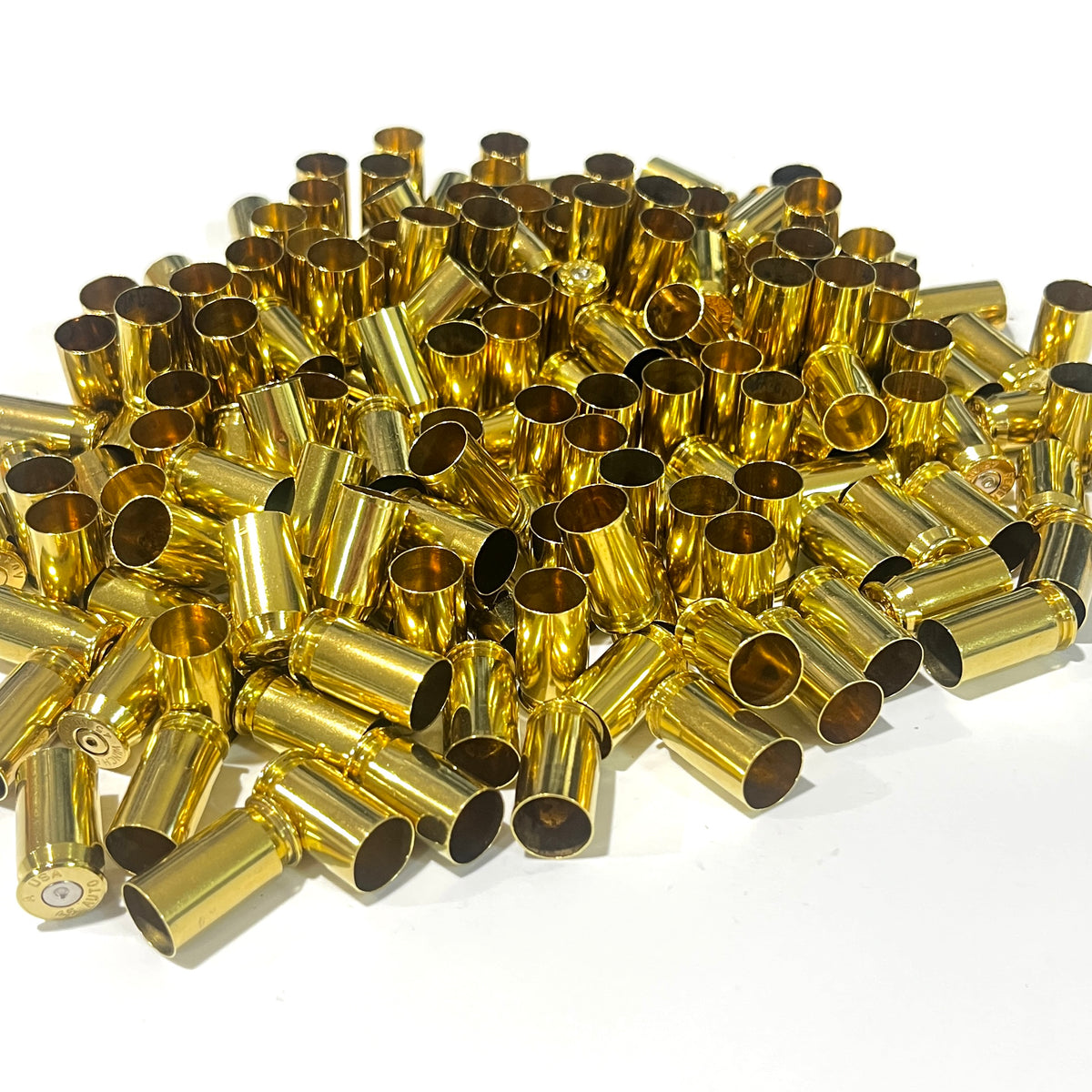 Large bulk pile of once fired gold 45 ACP brass shells, case mouths facing up, a few rims visible at the edges.
