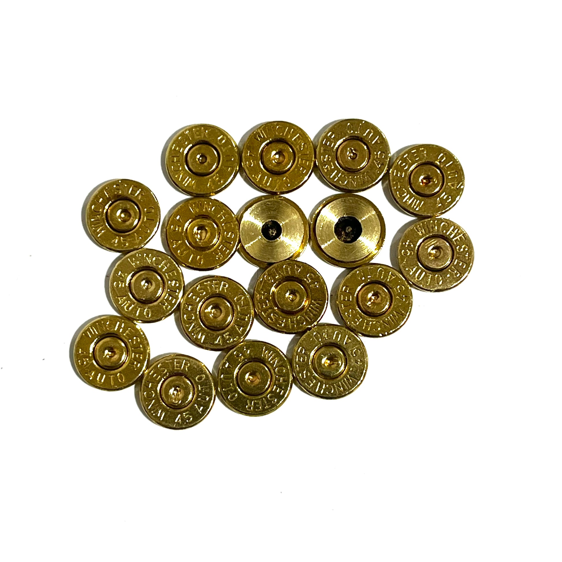 Close-up of gold 45 ACP brass bullet slices with Winchester headstamps, some with drilled holes