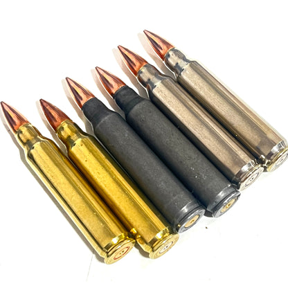 Six .223/5.56 casings in black, brass, and silver finishes lie diagonally, showing their base rims.