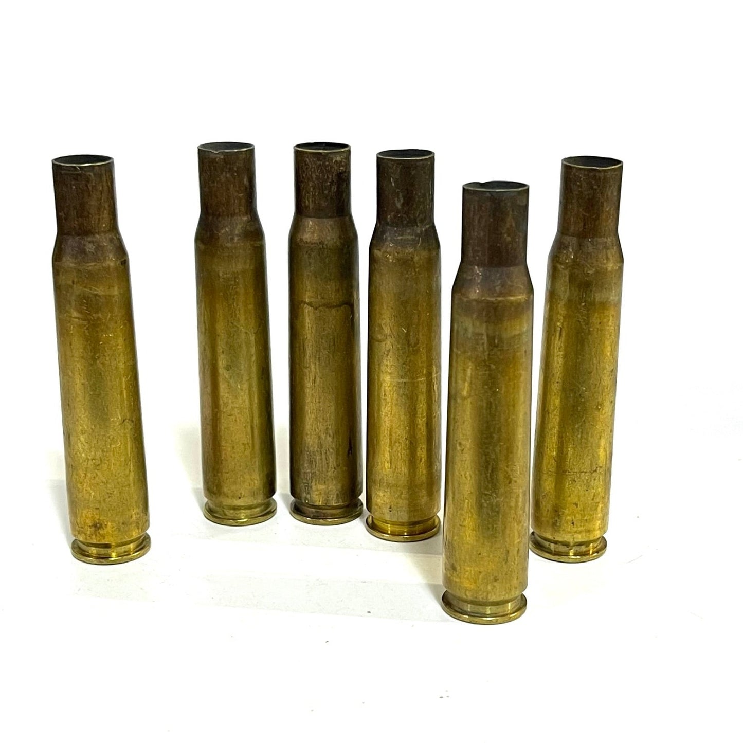 .50 BMG brass casing, approximately 3.91 inches, uncleaned raw condition on white background.