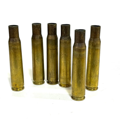 .50 BMG brass casing, approximately 3.91 inches, uncleaned raw condition on white background.