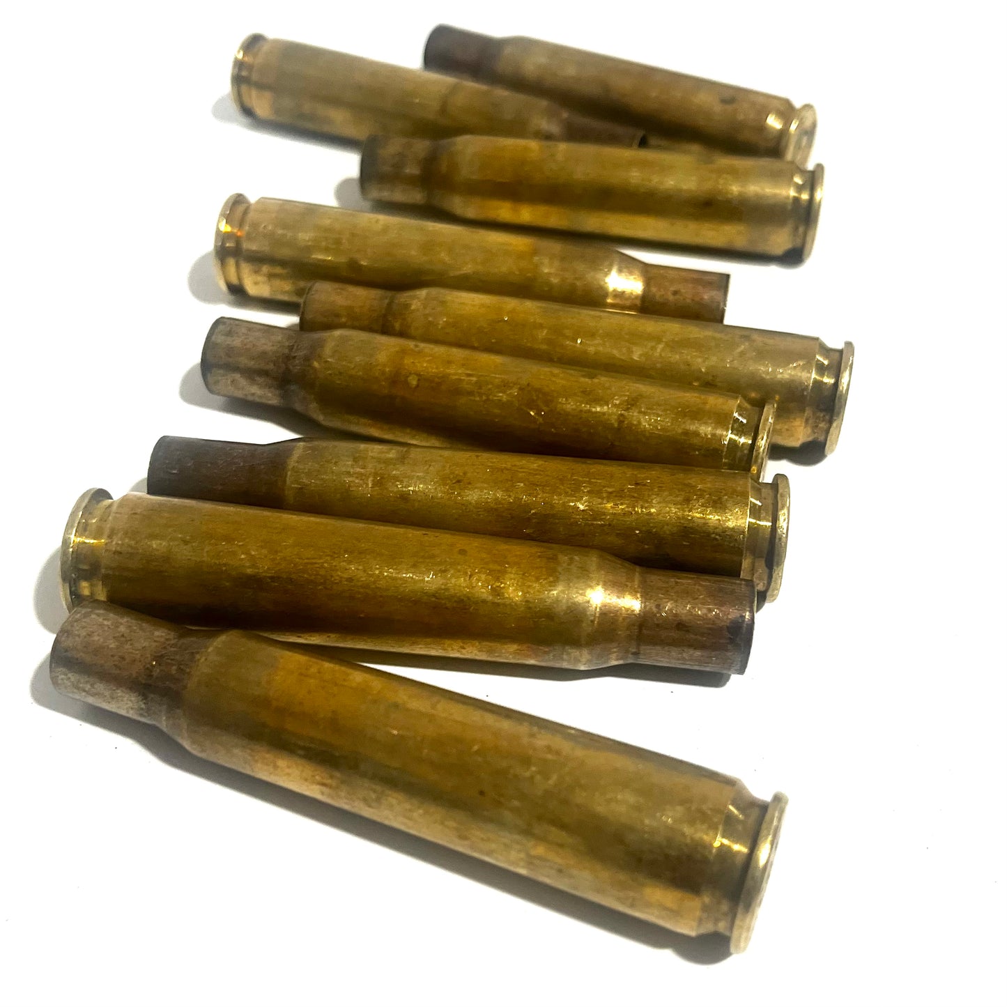 Dirty .50 BMG brass casing with mixed headstamps, inspected for dents and rust.