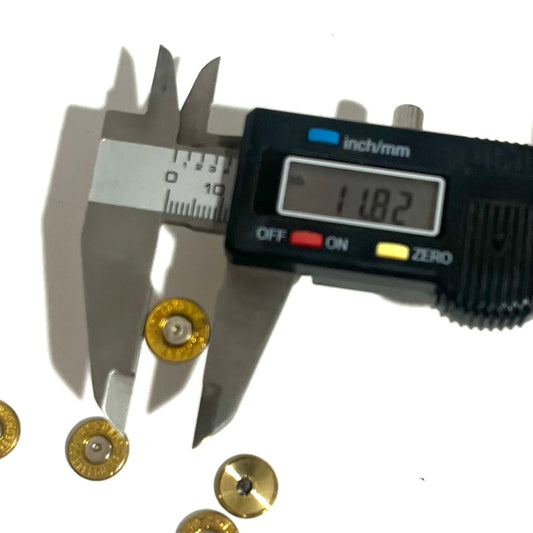 Digital caliper measuring the diameter of a 6.5 Creedmoor brass bullet slice at 11.82mm, more slices scattered nearby