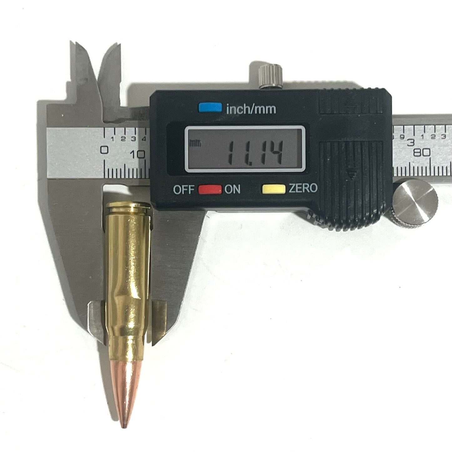 Measuring a 7.62x39 replica display bullet with digital calipers for film production prop accuracy.
