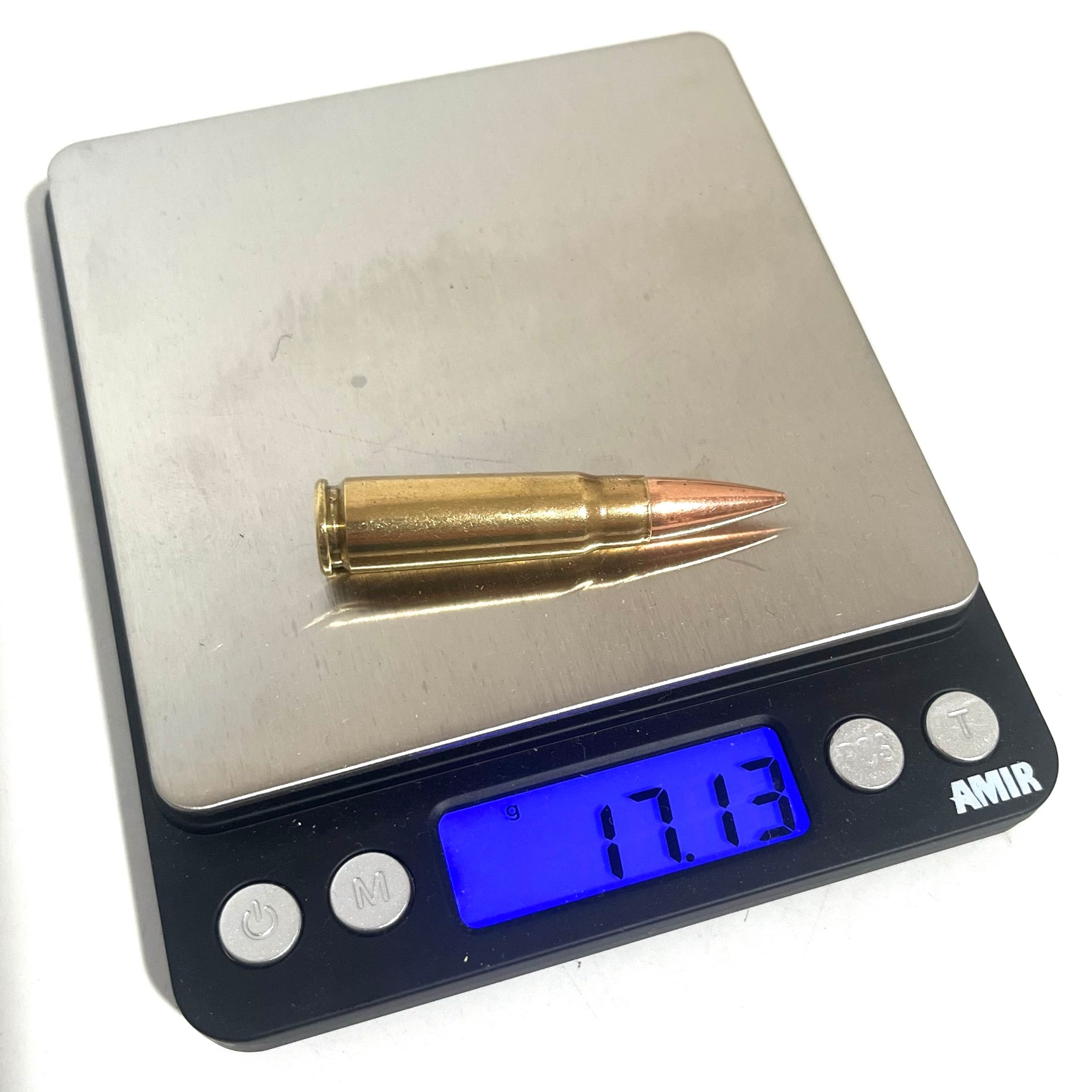 Measuring the weight of a 7.62x39 replica display bullet on a digital scale for film production prop realism.

