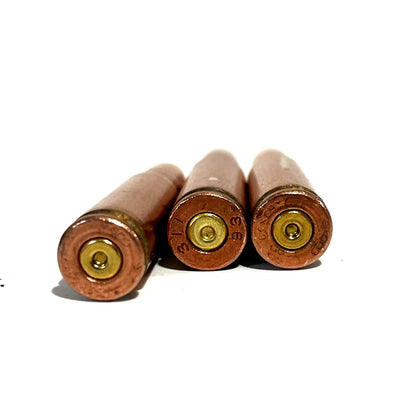 3 copper 7.62x39 dummy rounds viewed from the base showing primers and headstamps