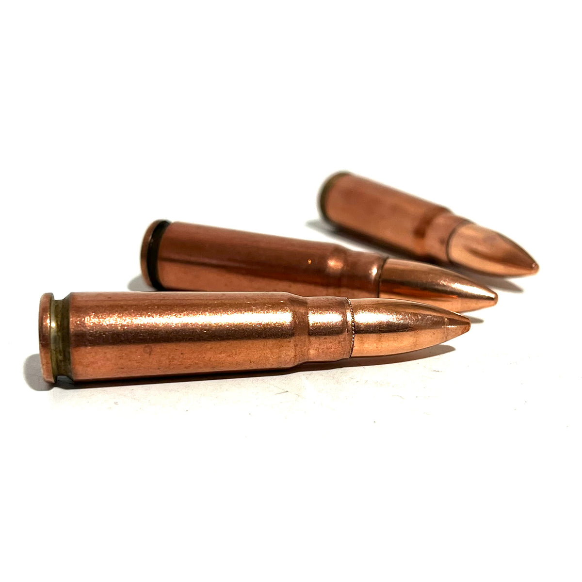 3 copper 7.62x39 dummy rounds lying on a white background