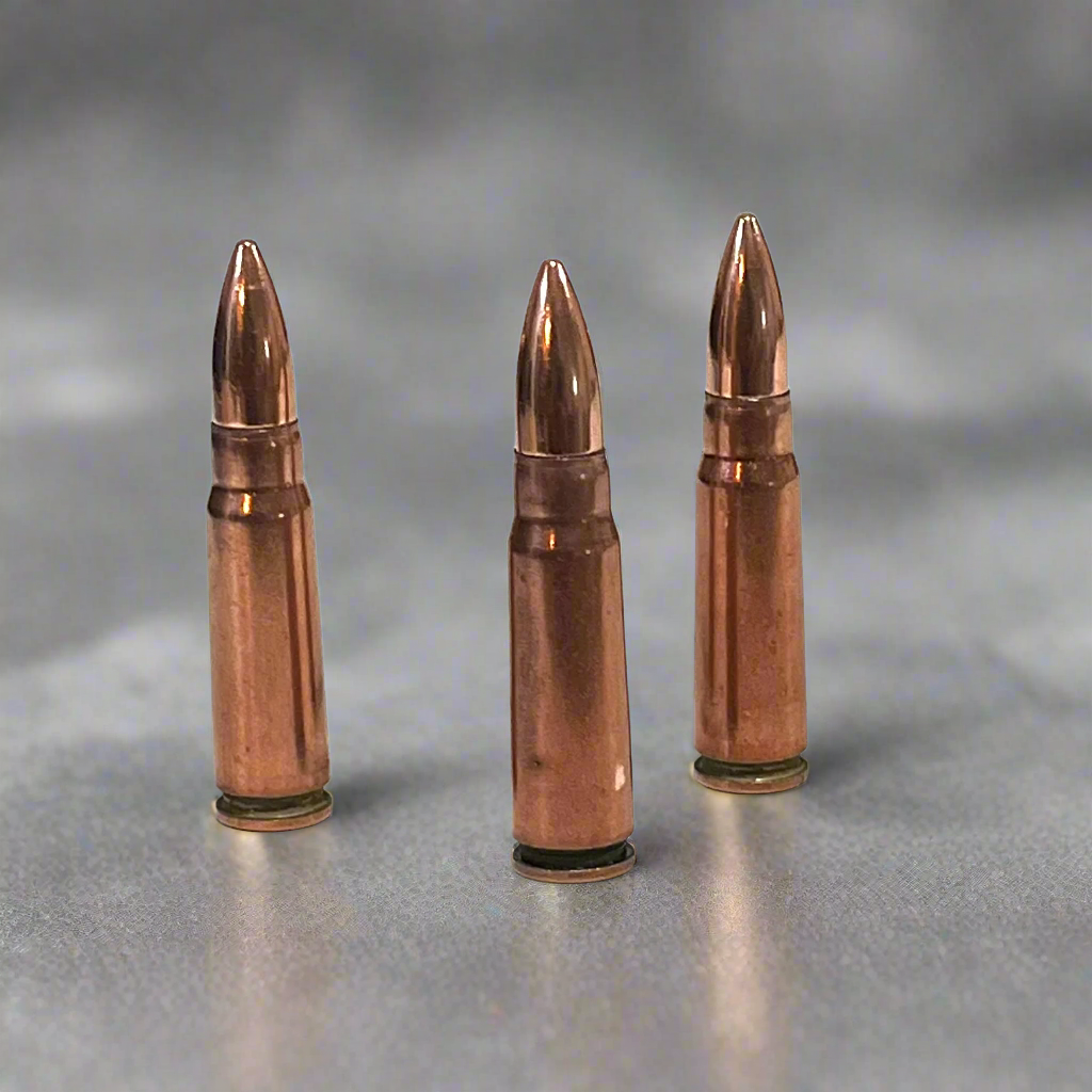 3 copper 7.62x39 dummy rounds standing upright on a gray background
