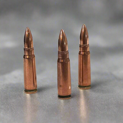 3 copper 7.62x39 dummy rounds standing upright on a gray background