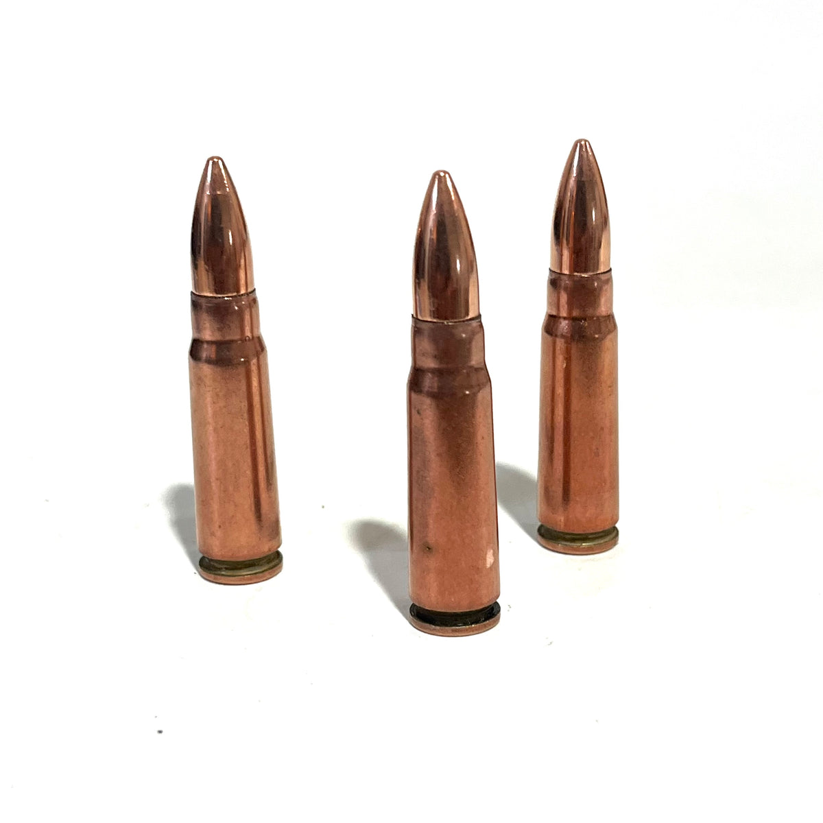 3 copper 7.62x39 dummy rounds standing upright on a white background