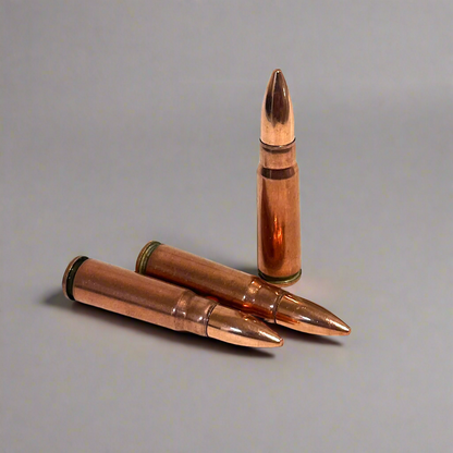 3 copper 7.62x39 dummy rounds, two lying down and one standing upright, on a gray background